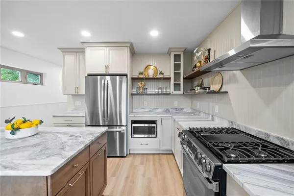 a kitchen with stainless steel appliances granite countertop a refrigerator a stove and a sink