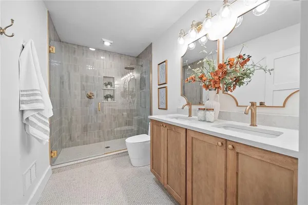 a bathroom with a sink a toilet and shower