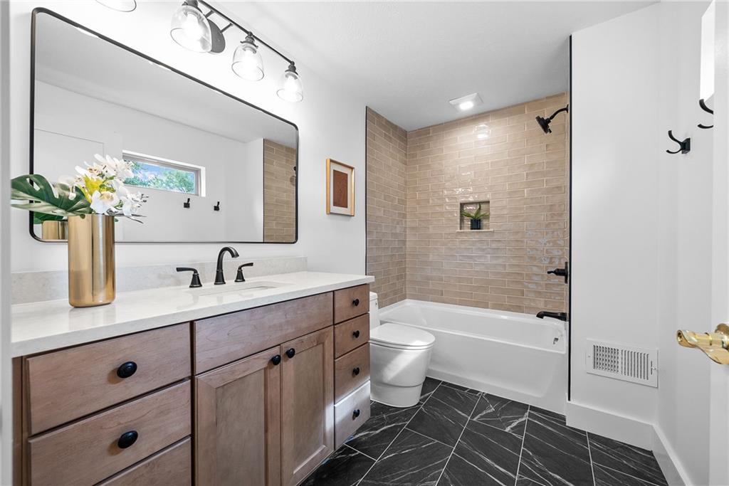 1431 Adams Street Pittsburgh, PA 15233 - Photo 26 of 42 a bathroom with a granite countertop toilet a sink a mirror a bathtub and shower