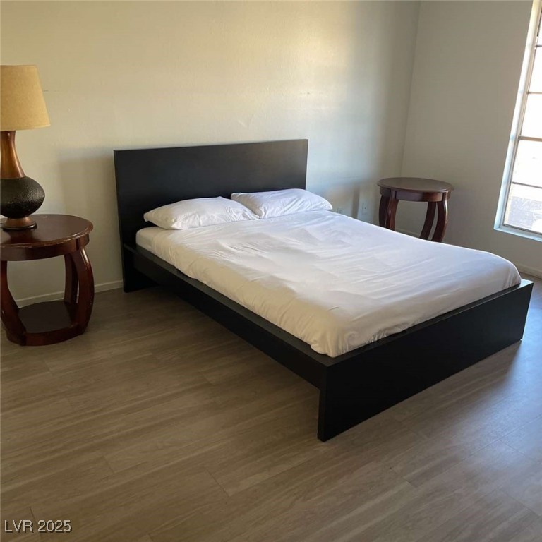 Bedroom featuring wood finished floors and baseboards