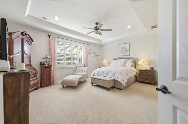 a bedroom with a bed flat screen tv and windows