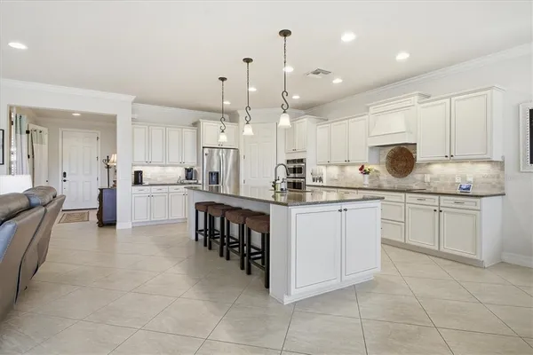 a living room with furniture kitchen view and a large window