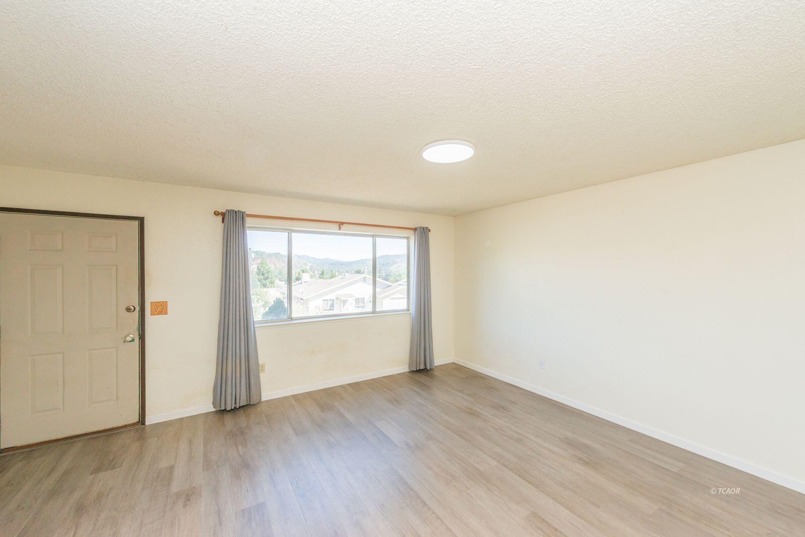 10 2nd Avenue Lewiston, CA 96052 - Photo 5 of 41 an empty room with wooden floor and window