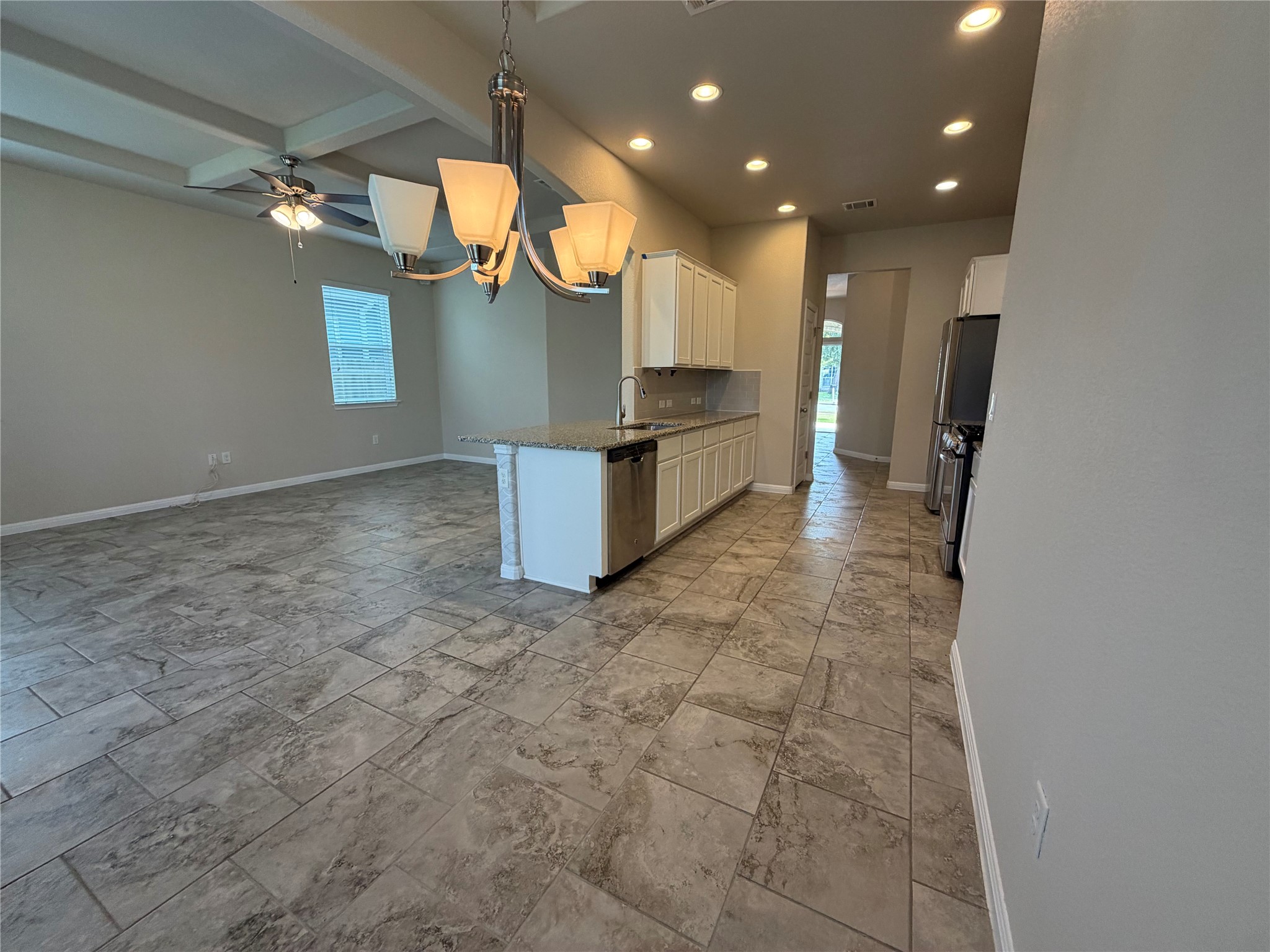 419 Gettysburg Loop Elgin, TX 78621 - Photo 13 of 21 An open concept kitchen flows seamlessly into the living space, defined by a spacious island with a sink.