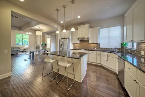a large white kitchen with lots of counter space a sink and appliances