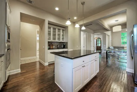 a kitchen with stainless steel appliances granite countertop wooden floors and view living room