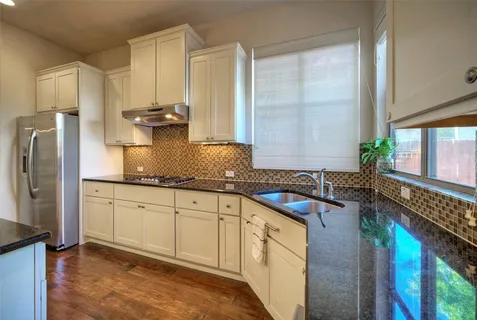 a kitchen with stainless steel appliances granite countertop a sink stove and refrigerator