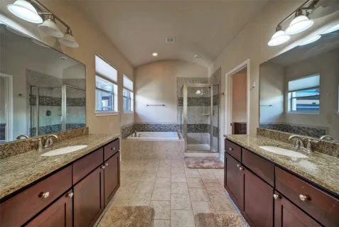 a spacious bathroom with a granite countertop sink mirror and a bath tub
