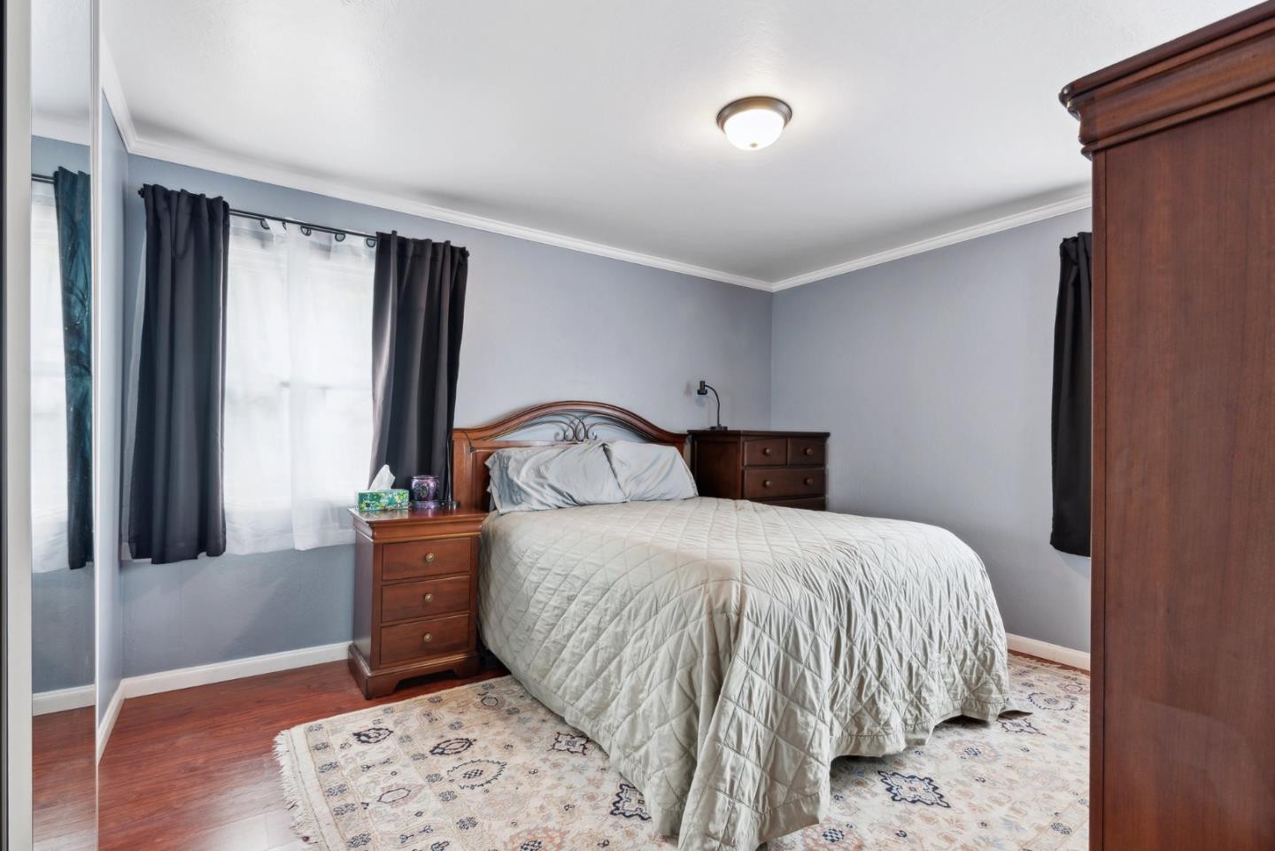 965 Monte Verde Drive Pacifica, CA 94044 - Photo 13 of 34 a bedroom with a bed and wooden floor