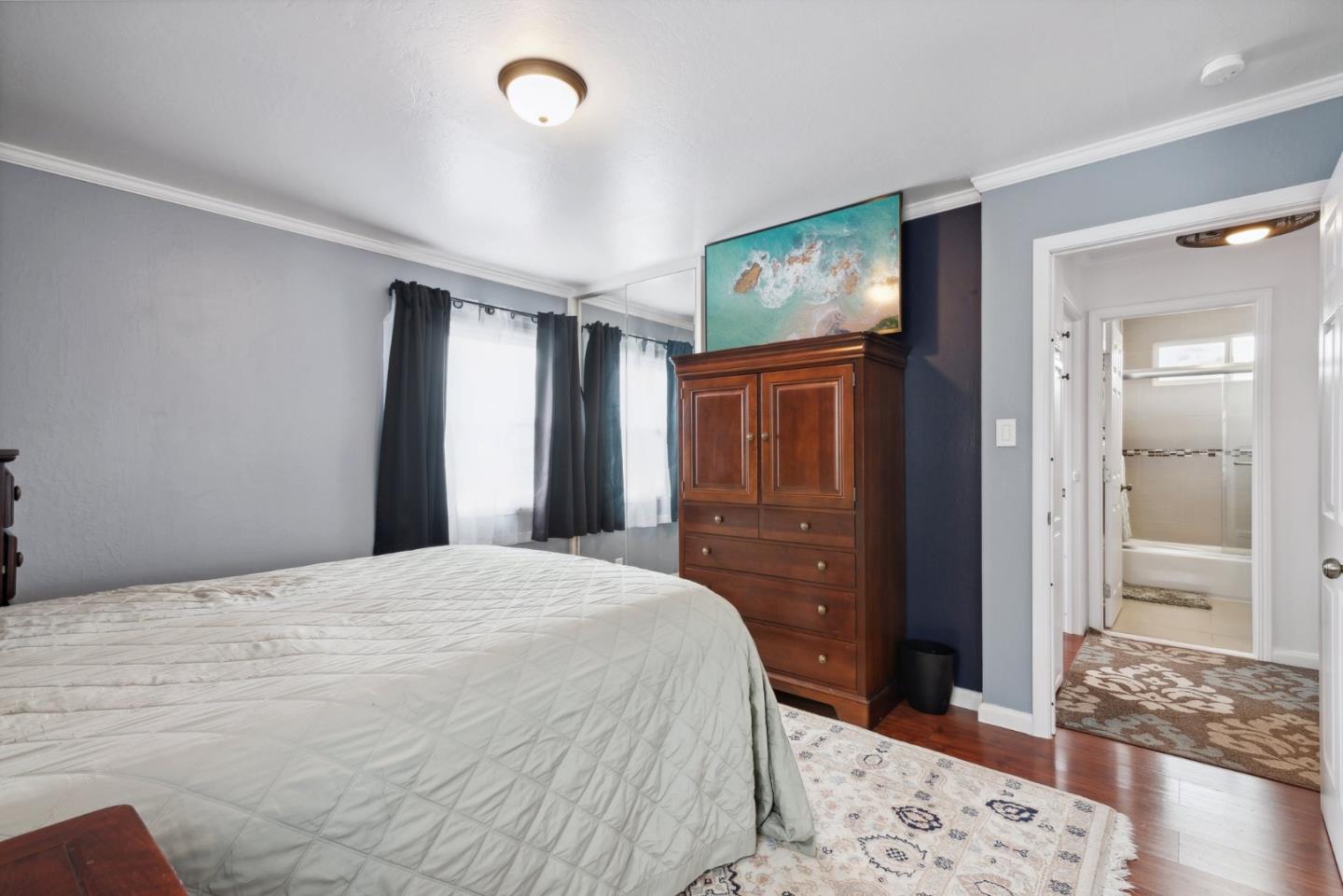 965 Monte Verde Drive Pacifica, CA 94044 - Photo 14 of 34 a bedroom with a bed and wooden floor