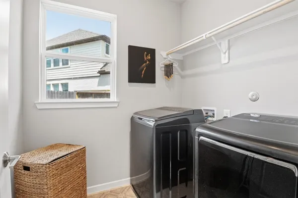 a kitchen with stainless steel appliances granite countertop a dining table chairs refrigerator and microwave