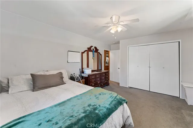 a bedroom with a large bed a chandelier and a dresser