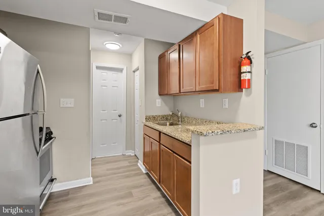 a kitchen with stainless steel appliances granite countertop a refrigerator and a stove