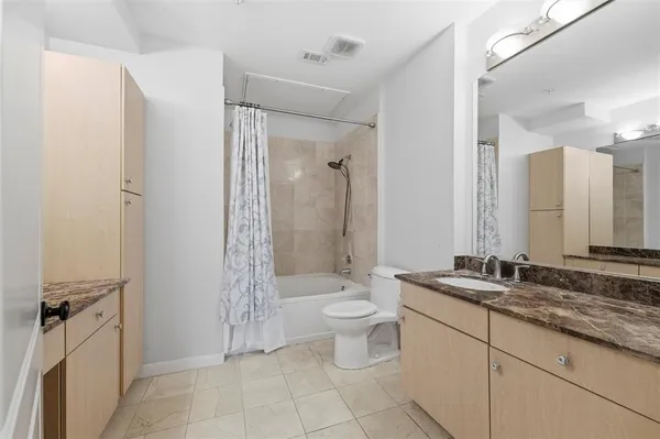 a bathroom with a granite countertop sink toilet and shower