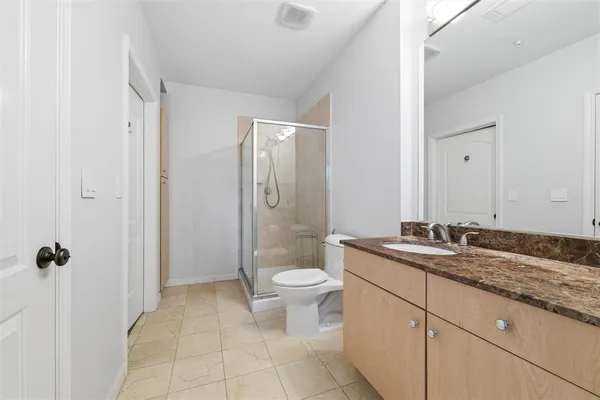 a bathroom with a granite countertop sink a toilet and a mirror