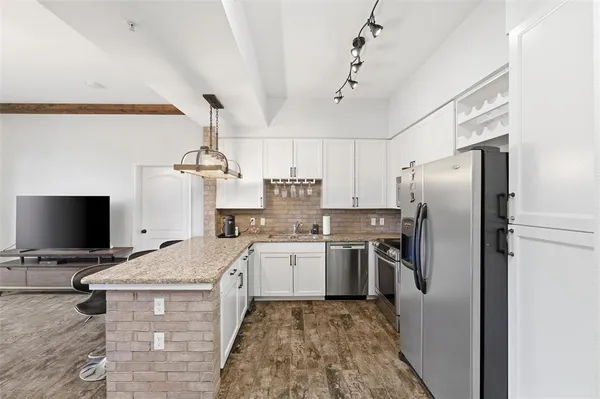 a kitchen with stainless steel appliances granite countertop a refrigerator a stove and a sink