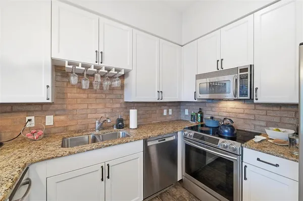 a kitchen with stainless steel appliances granite countertop a sink stove and cabinets