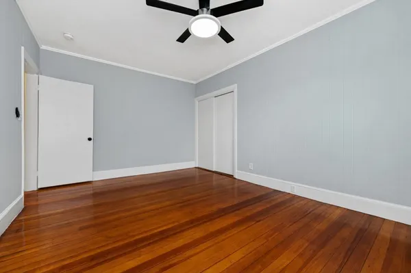 a view of empty room with wooden floor