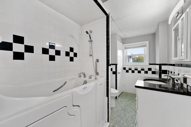 a bathroom with a bathtub sink mirror and shower