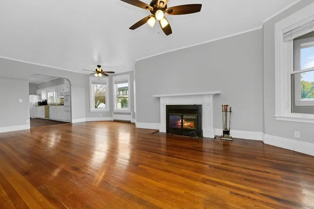 a view of an empty room with window and wooden floor