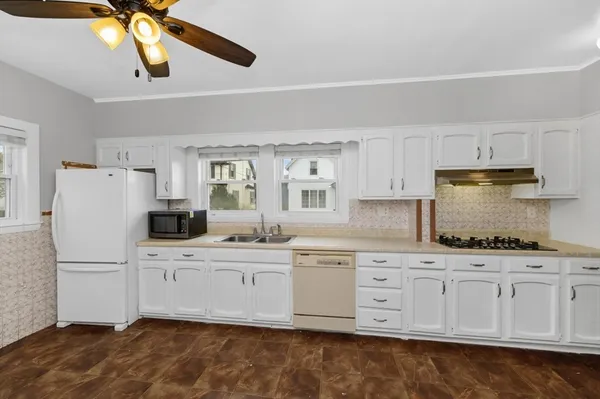a kitchen with white cabinets sink and refrigerator