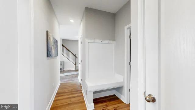 a view of a hallway with wooden floor and entryway