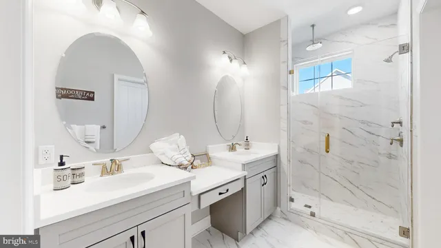 a bathroom with a double vanity sink mirror and shower