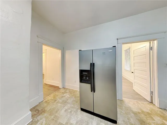 a view of a kitchen with a refrigerator and an entryway