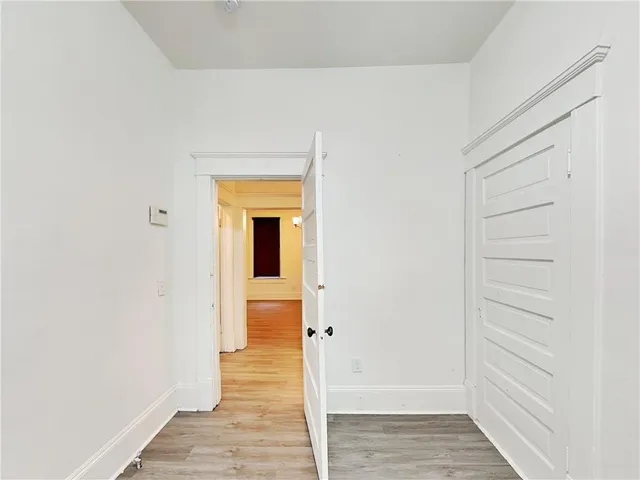 a view of a hallway with wooden floor and entryway