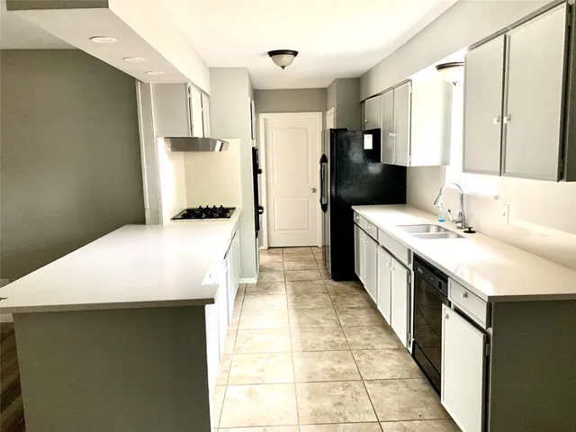 a kitchen with a sink a stove top oven a refrigerator and a window