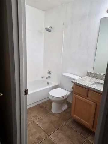 a bathroom with a granite countertop toilet a sink and bathtub