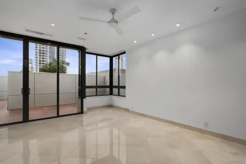 a living room with furniture ceiling fan and a floor to ceiling window