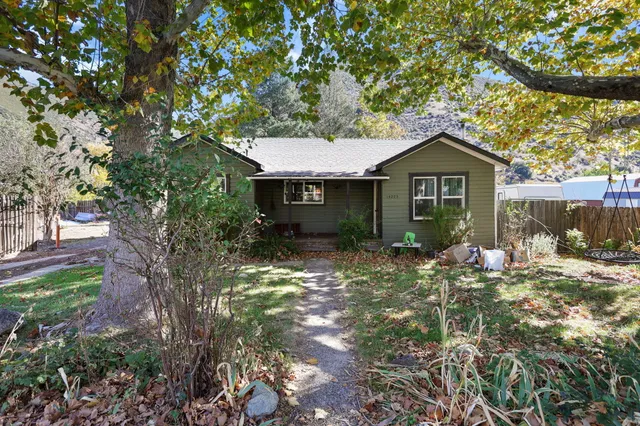 a view of a house with a yard tree and sitting area