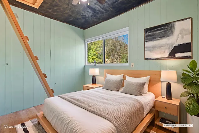 a view of an empty room with wooden floor and stairs