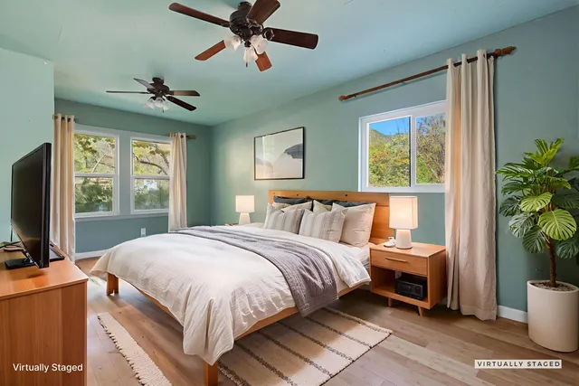 a view of an empty room with a window and a ceiling fan