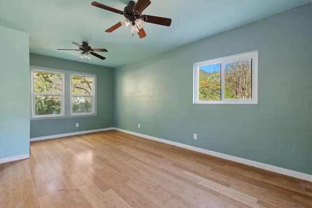 a view of a hallway with a chandelier fan and wooden floor