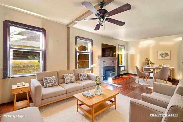 a view of a livingroom with wooden floor and a ceiling fan