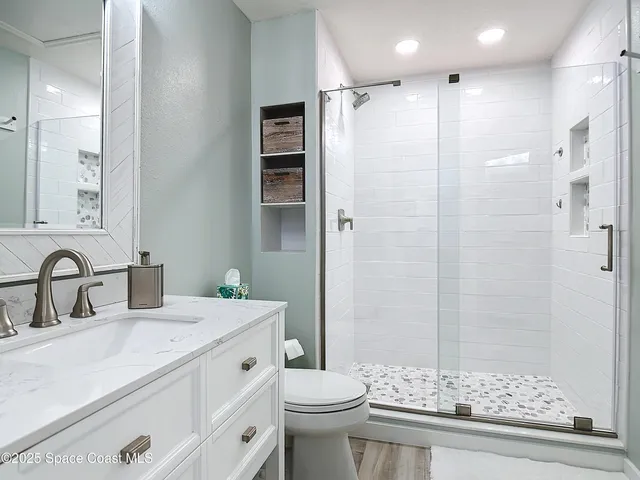 a bathroom with a double vanity sink toilet and shower