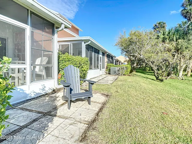 a view of a house with backyard and sitting area