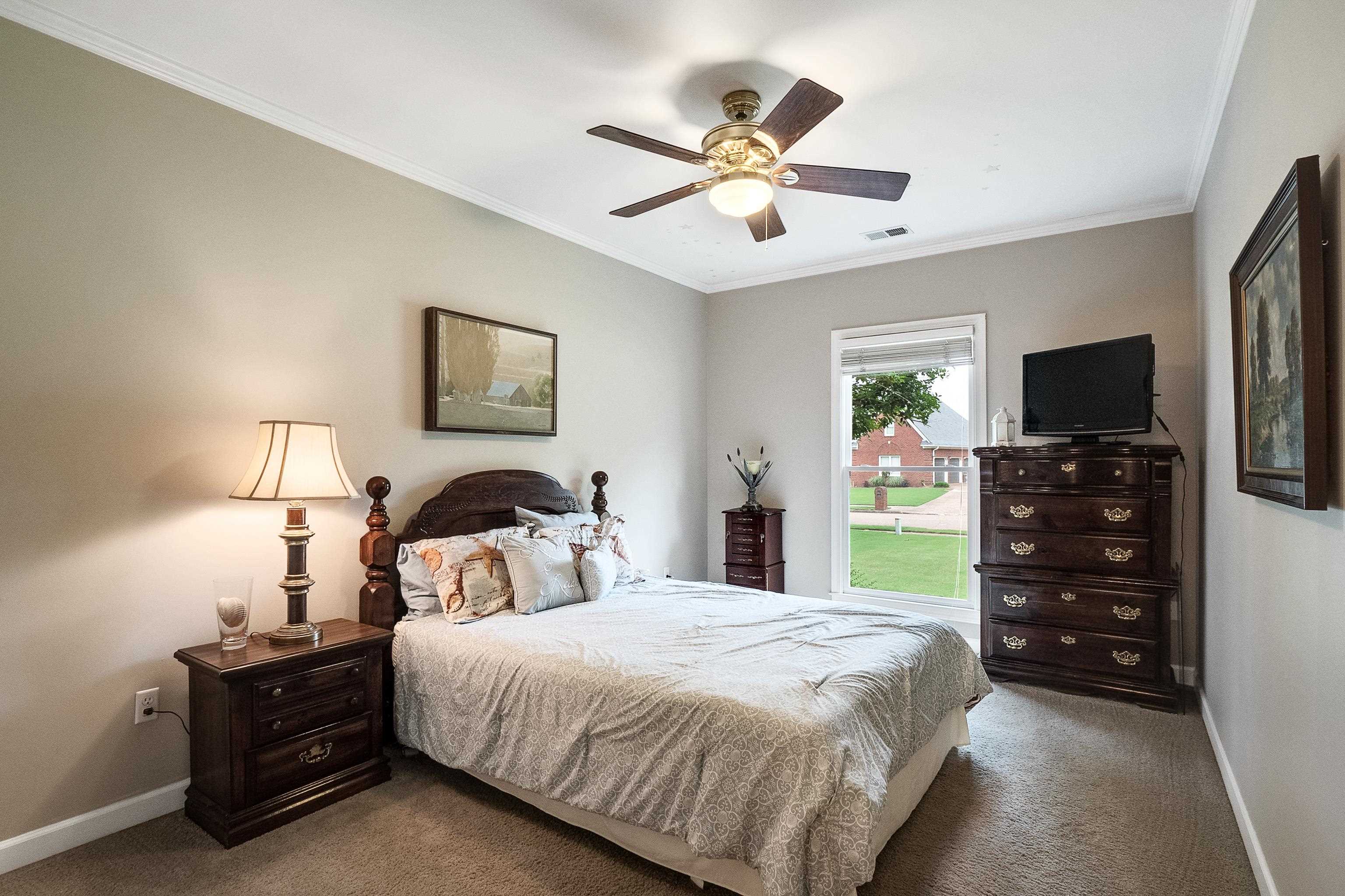 1050 Crosswinds Cove Collierville, TN 38017 - Photo 20 of 40 a bedroom with a bed and a flat tv screen on dresser