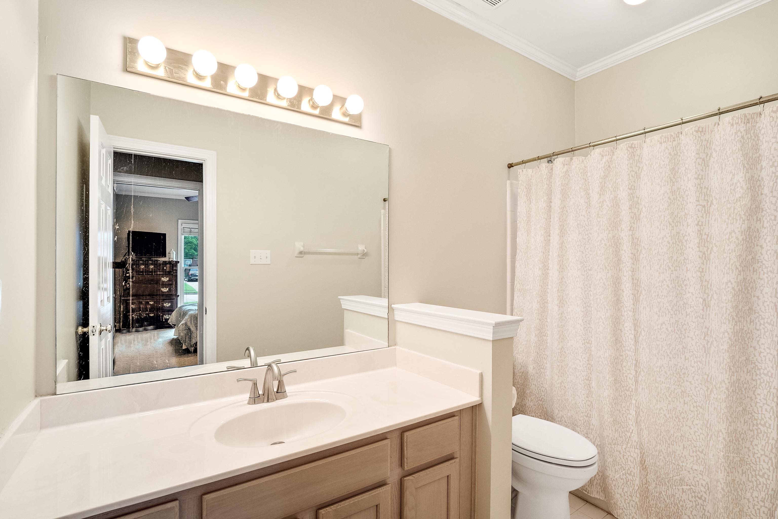 1050 Crosswinds Cove Collierville, TN 38017 - Photo 21 of 40 a bathroom with a sink a toilet a mirror and shower curtain