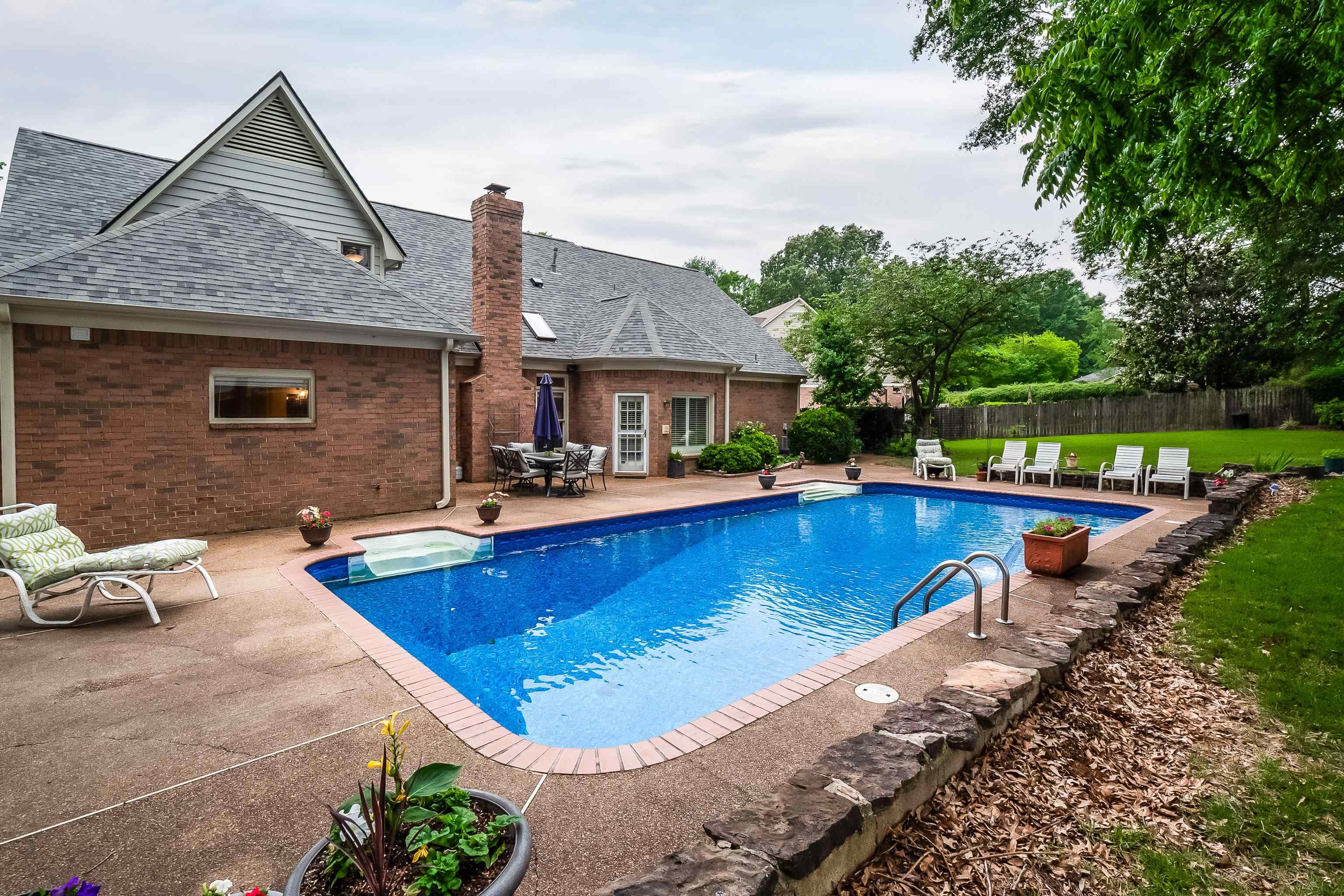 1050 Crosswinds Cove Collierville, TN 38017 - Photo 8 of 40 a view of a house with pool lawn chairs and a yard