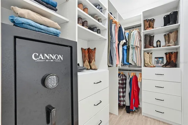 a view of walk in closet with clothes and shoes