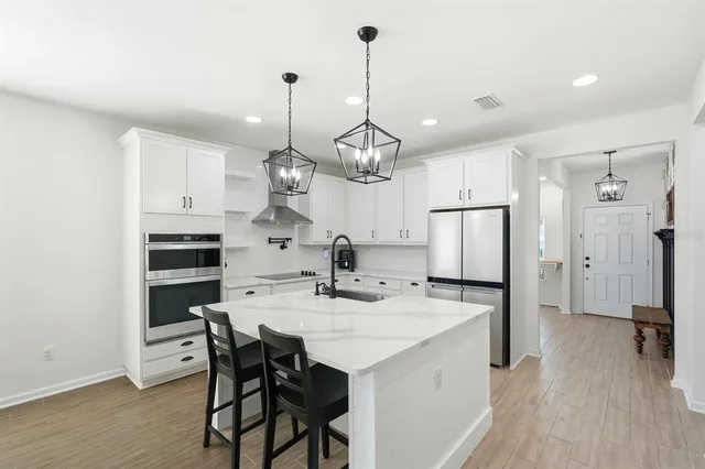 a kitchen with a dining table chairs refrigerator and cabinets