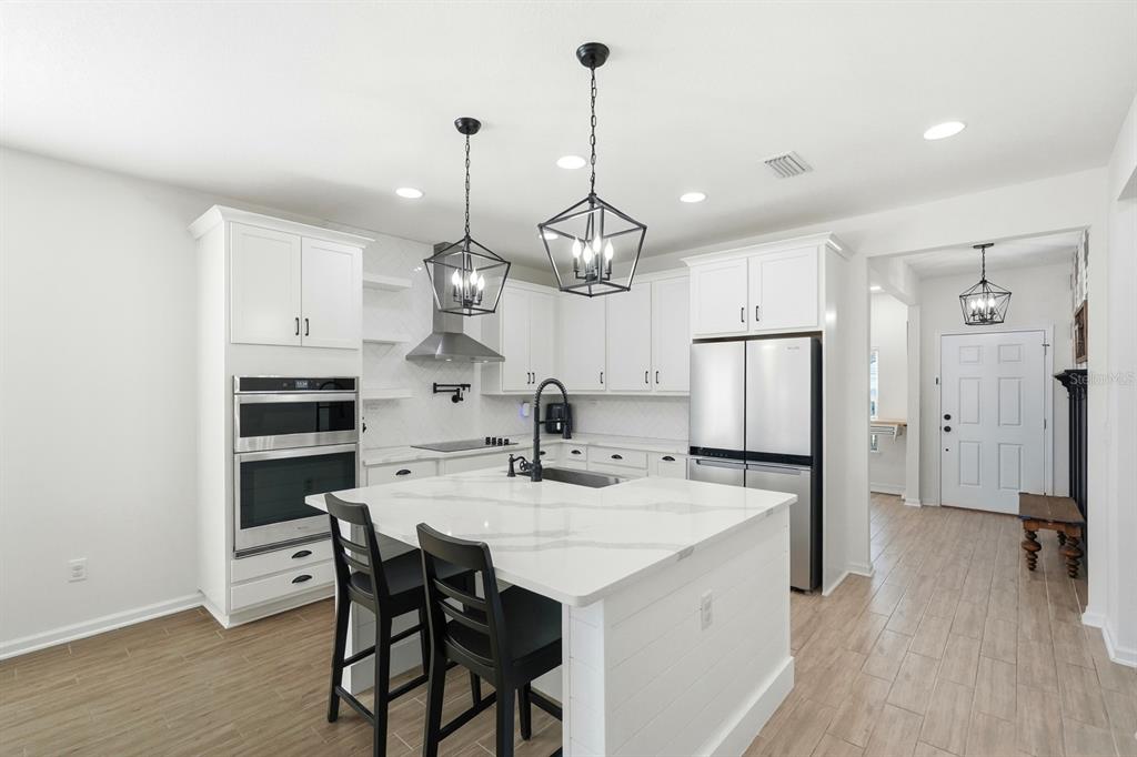 140 Nighthawk Lane Palm Coast, FL 32164 - Photo 23 of 43 a kitchen with a dining table chairs refrigerator and cabinets