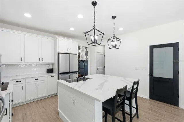 a kitchen with kitchen island granite countertop a sink a center island and cabinets
