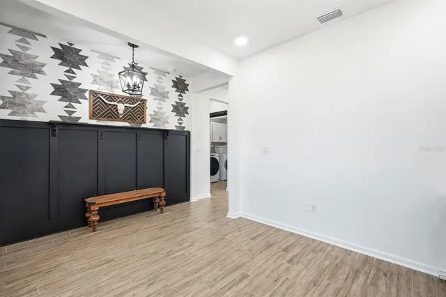 a view of a hallway with wooden floor and a bathroom