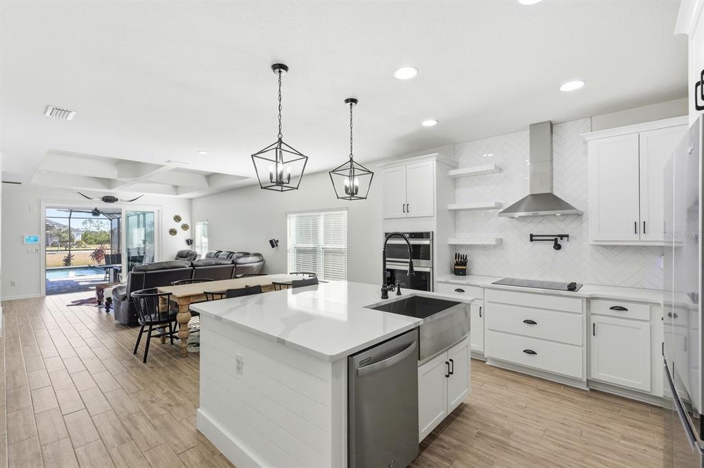 140 Nighthawk Lane Palm Coast, FL 32164 - Photo 3 of 43 a kitchen with a stove a refrigerator a sink dishwasher with a dining table and chairs with wooden floor