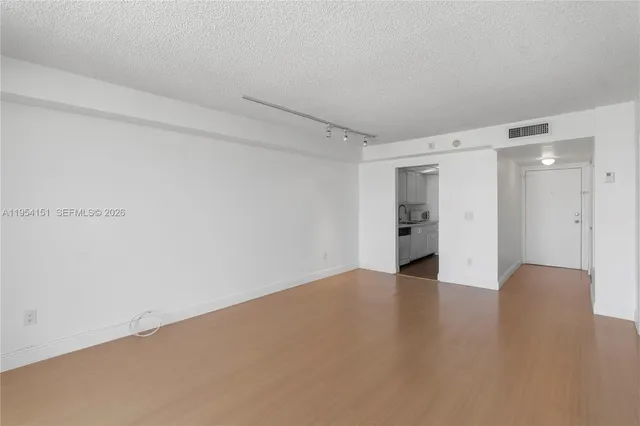 a view of an empty room with wooden floor