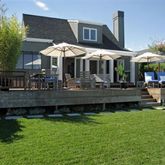 a backyard of a house with barbeque oven table and chairs